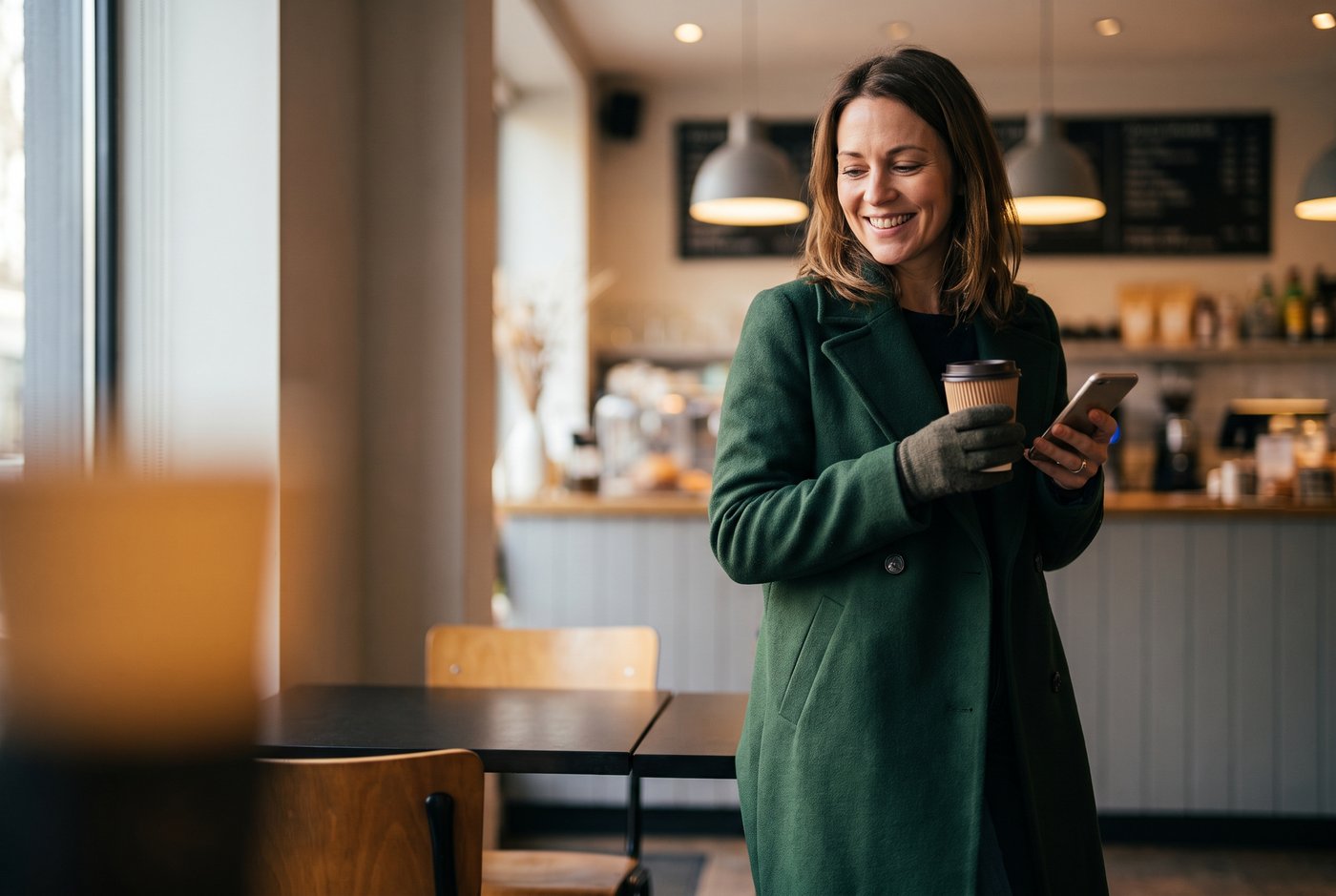A member picking up coffee and checking her phone